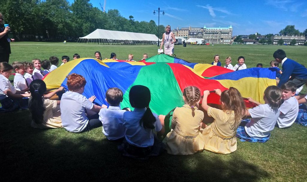 Students holding a multicoloured parachute