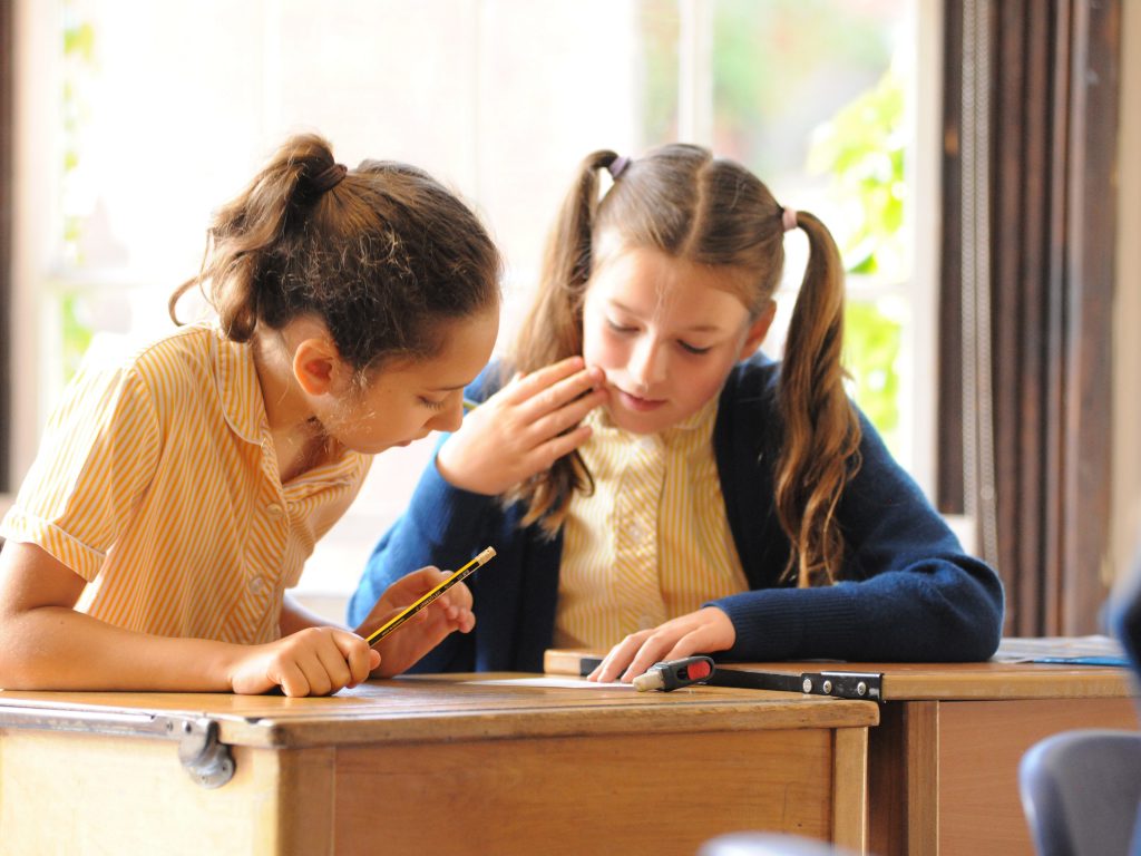 2 students looking at the answers on a worksheet