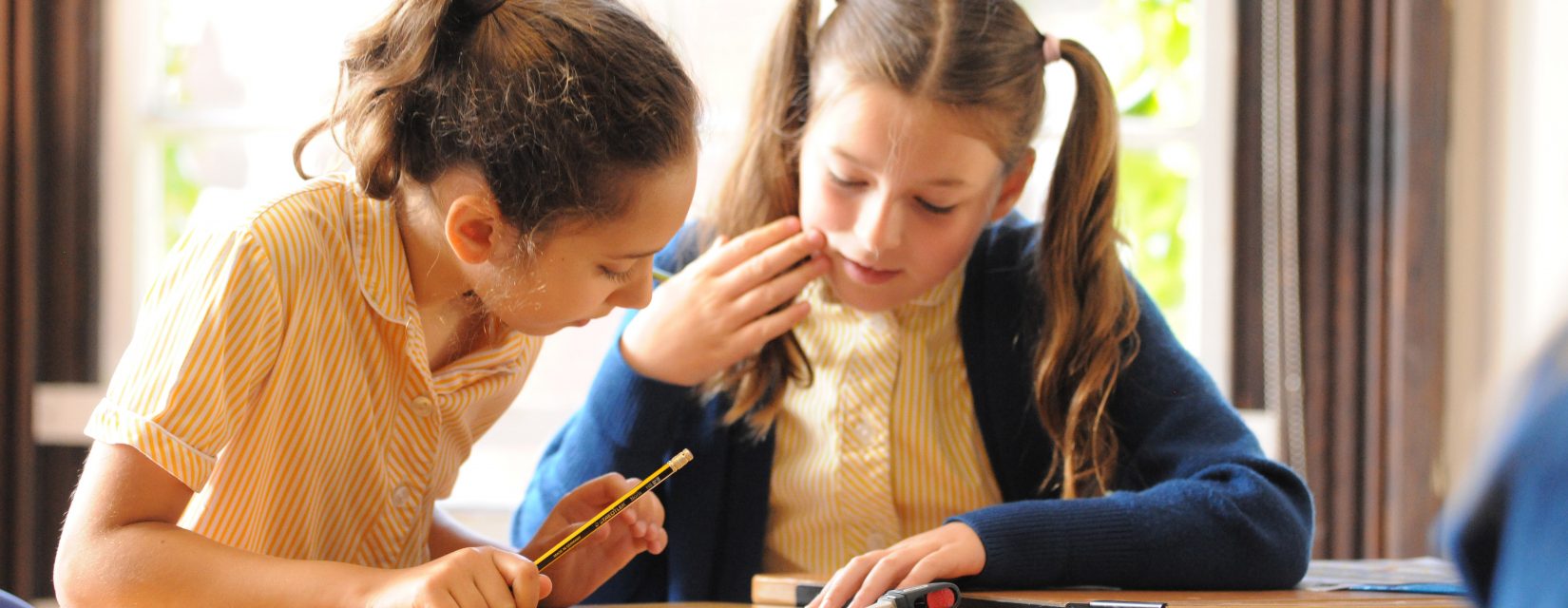 2 students looking at the answers on a worksheet