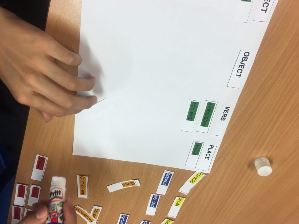 student sticking vocab on paper