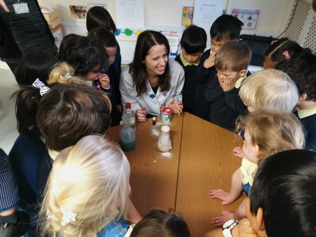 teacher performing a science experiment infront of children