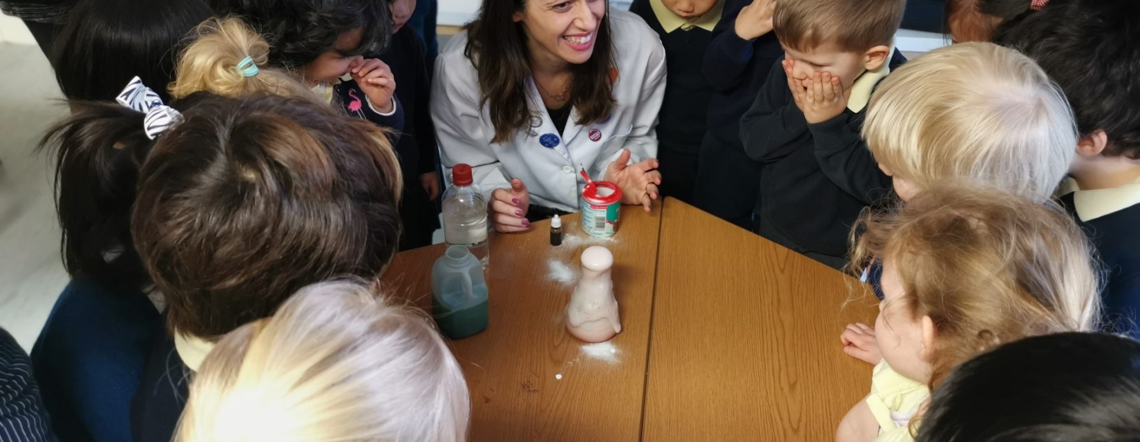 teacher performing a science experiment infront of children