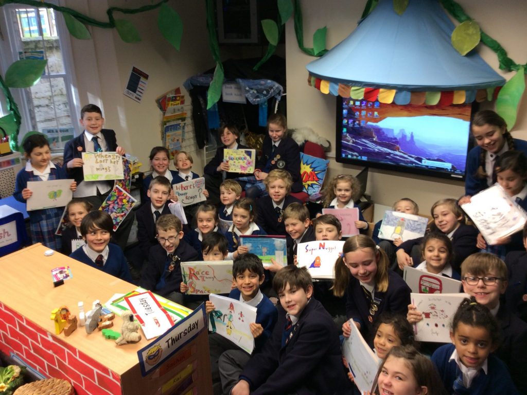 students holding up their drawings