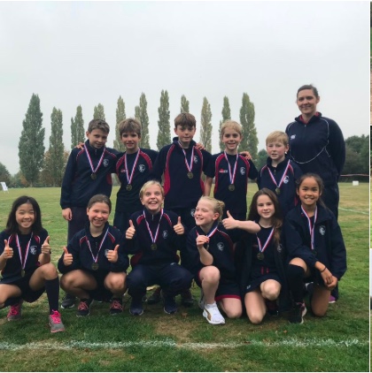 Students wearing medals with the Coach