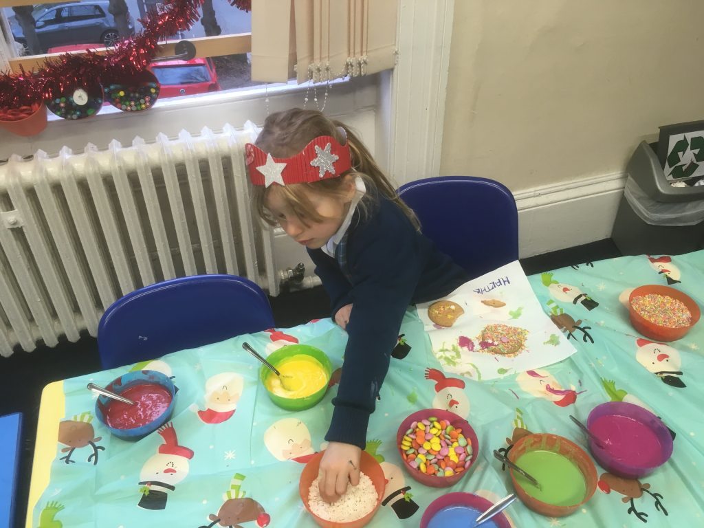 Young girl making cookies with different toppings