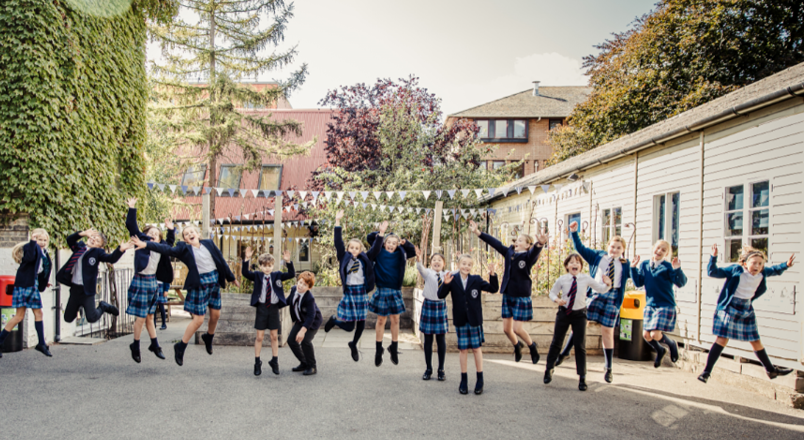 pupils in uniform jumping