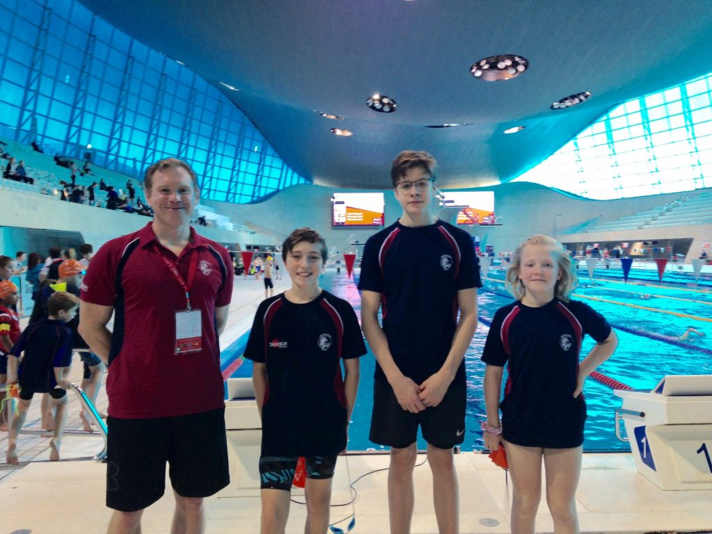 3 students and a coach in the swimming pool
