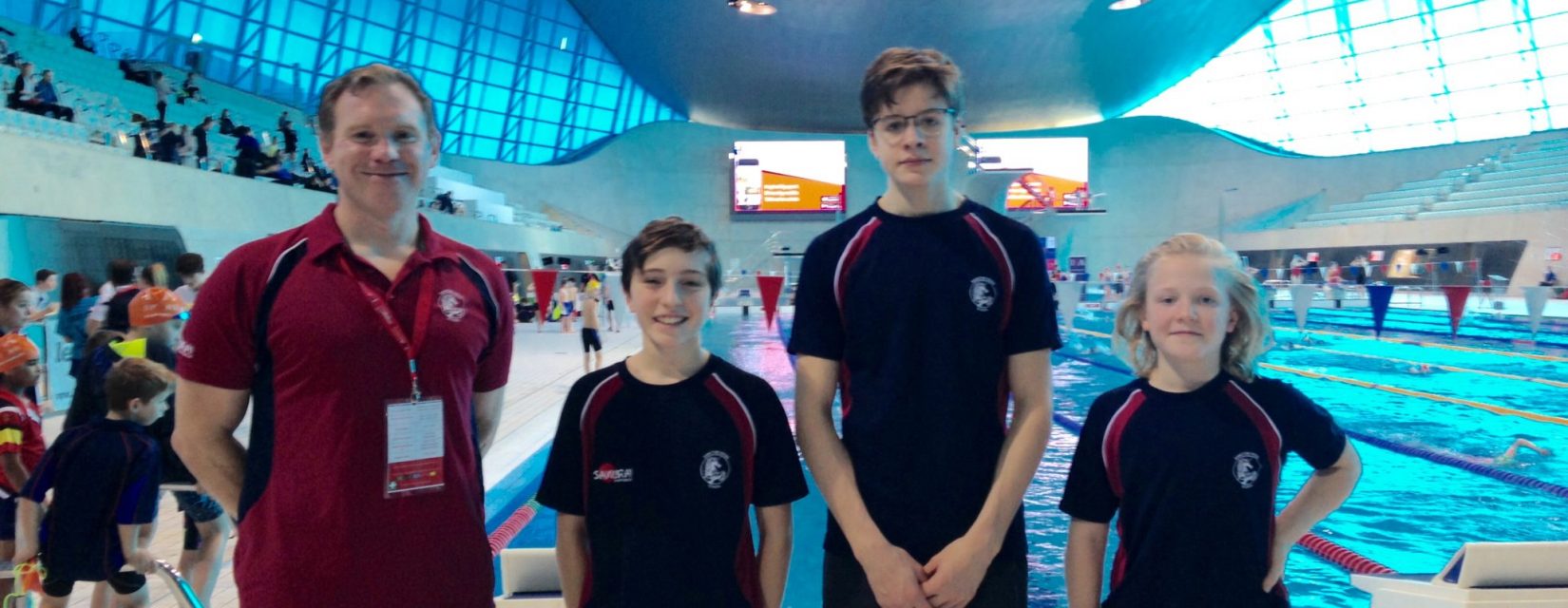 3 students and a coach in the swimming pool