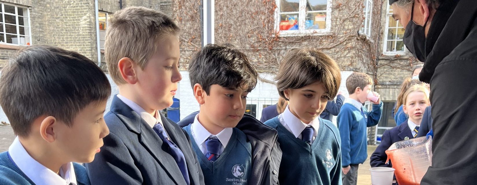 children waiting for soup outdoors