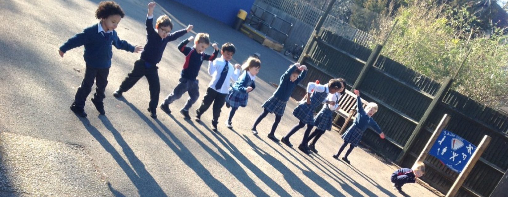 children standing in a line with their arms up