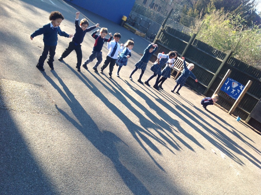 children standing in a line with their arms up